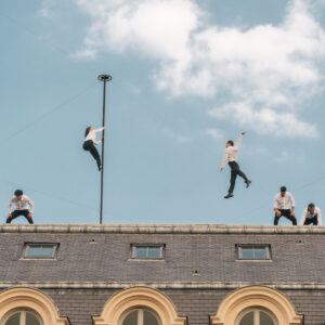 Photographie du spectacle Horizon sur les toits du Palais-Royal à Paris avec des acrobates et circassiens.