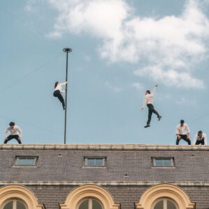 Photographie du spectacle Horizon sur les toits du Palais-Royal à Paris avec des acrobates et circassiens.